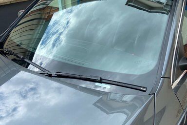 Grey Nissan gets new front windscreen in the garage at home